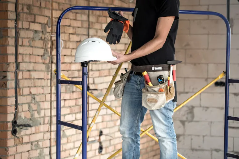 Construction worker preparing for an exterior renovation near scaffolding